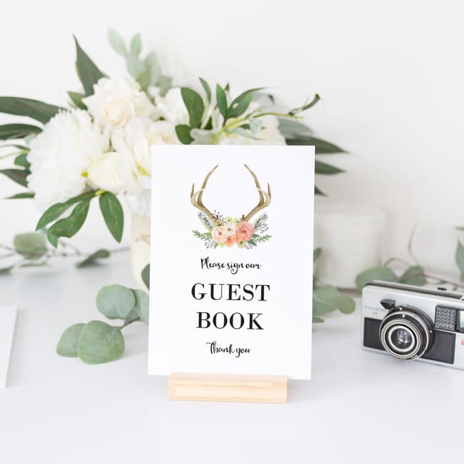 please sign our guestbook printed on white card in wooden stand