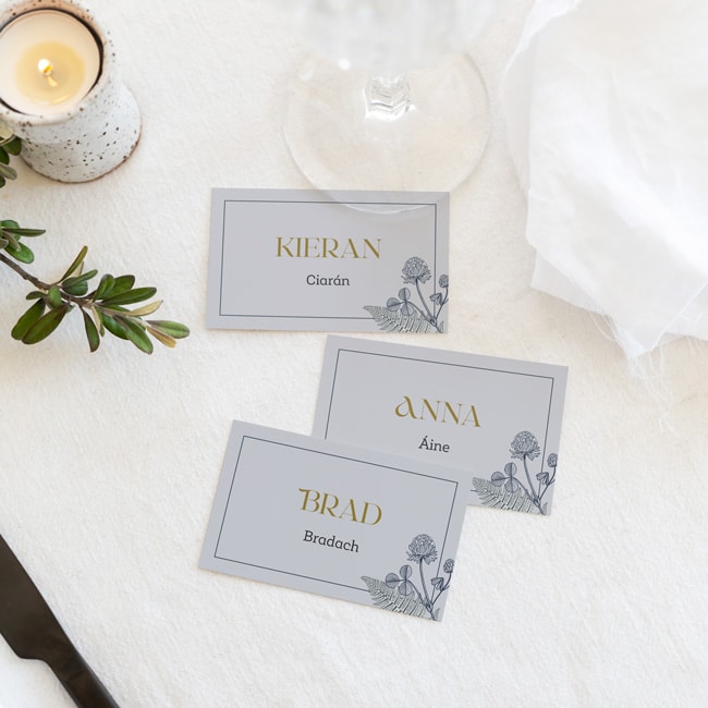 Green place card sitting on rose, napkin and plate