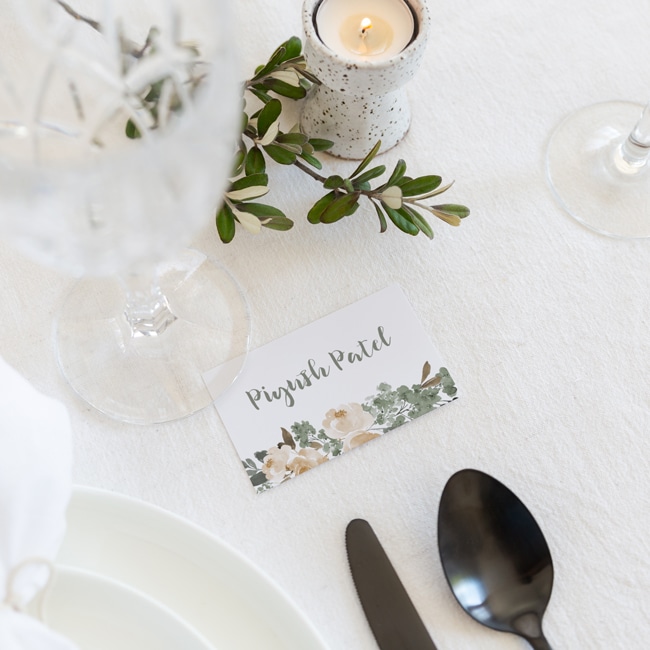 placecard with guests name in green with peony flowers sitting on napkin and plate