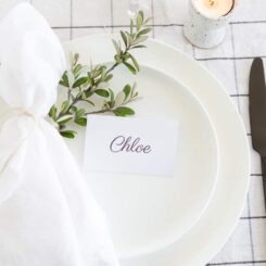 small white place name sitting on rose and napkin