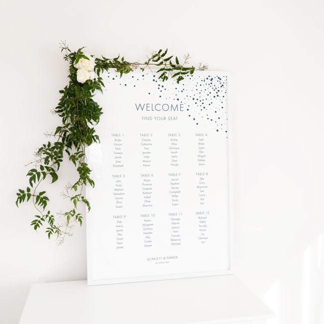 poster in white frame next to flowers in vase